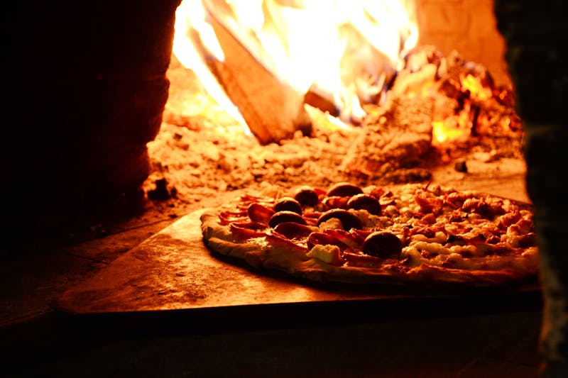 Freshly made marco's pizza coming out of the oven